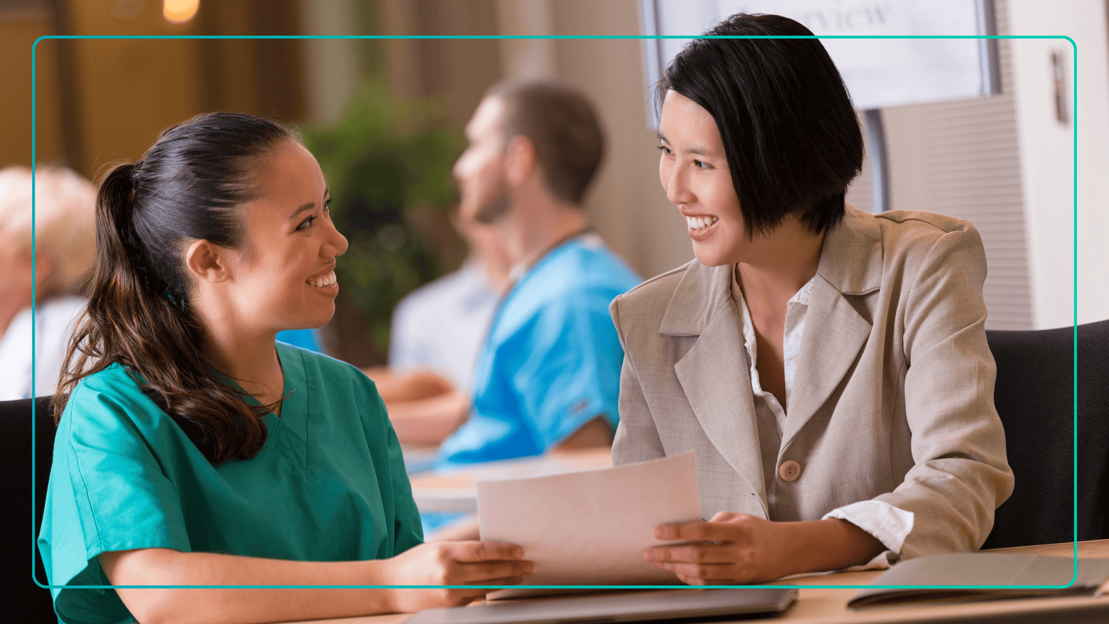 shows two professionals engaged in a discussion over documents during a candidate interview. The company specializes in connecting behavioral health professionals with organizations that need qualified care teams.